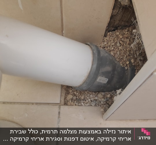 צינור פלסטיק לבן מחובר לקיר עם חיבור גומי
